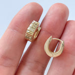 Model holding hoop earrings in 14K yellow gold.