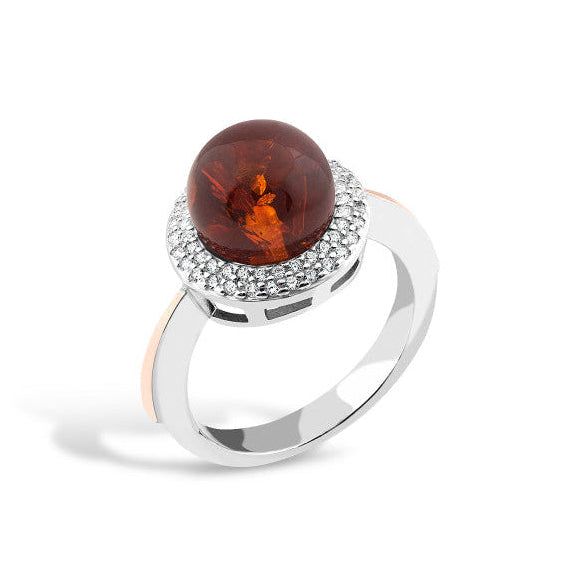 Silver ring with a large amber stone and smaller stones on a white background