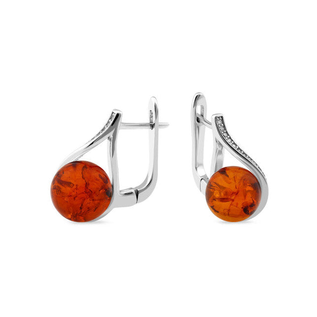Pair of silver earrings with amber-colored round stones on a white background