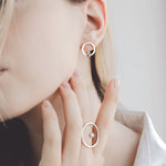 Model wearing set: lever back earrings in 14K white gold decorated with diamond-cut zirconium and 14K white gold ring decorated with zirconium.