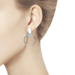 Model wearing Lever back circle drop earrings in 14K white gold.